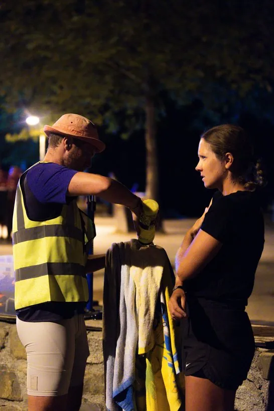 Crew und Athletin in der Wechselzone bei Nacht